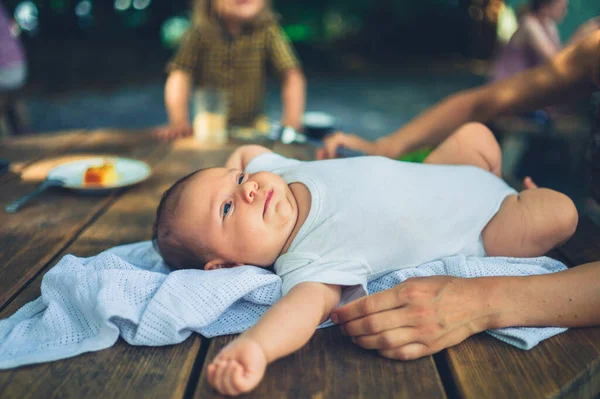 Uma Jovem Mãe Está Deitando Seu Bebê Uma Mesa Livre — Fotografia de Stock