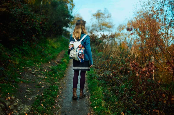 秋天的一天 一个年轻的女人在森林的小径上散步 — 图库照片