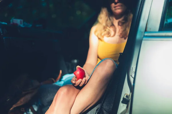 Een Jonge Vrouw Zit Een Auto Een Appel Eten — Stockfoto