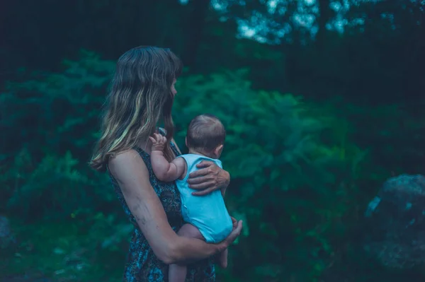 Una Joven Madre Sostiene Bebé Bosque Atardecer —  Fotos de Stock