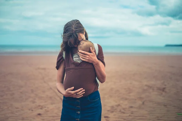 Una Joven Madre Está Pie Playa Con Bebé Cabestrillo —  Fotos de Stock