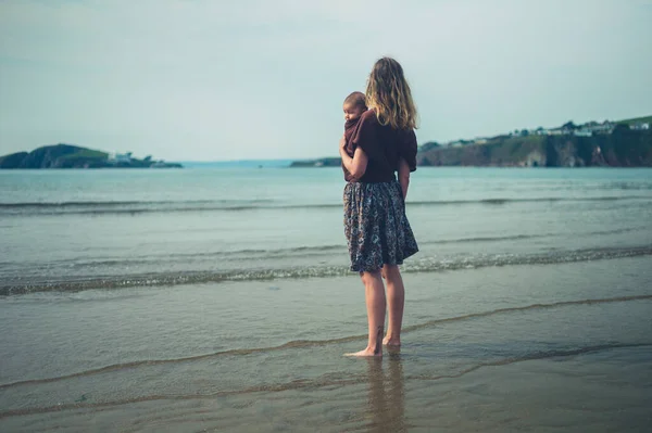 Una Joven Madre Está Pie Playa Con Bebé Cabestrillo —  Fotos de Stock