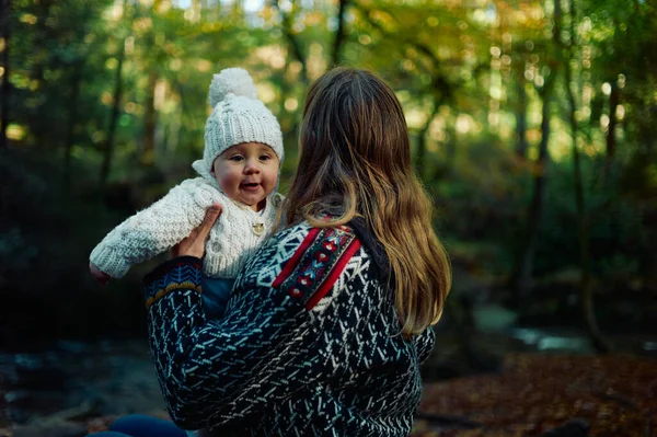 幼い母親が秋の晴れた日に赤ん坊と森の中にいる — ストック写真