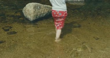 Nehir suyunda yürüyen bir kadının arka görüntüsü