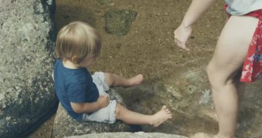 Kadın ve oğlu dağ nehrinde oynuyorlar.