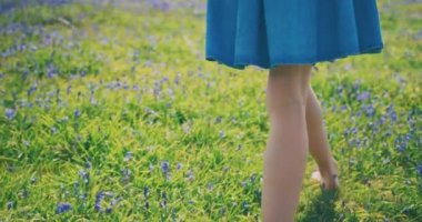 Yeşil alanda küçük çiçeklerle yürüyen dişi ayaklar.