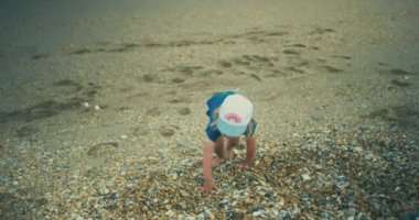 Tatlı küçük kız kayalık sahilde dinleniyor.