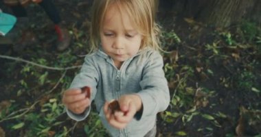 Küçük çocuk annesine bahçede yardım ediyor.