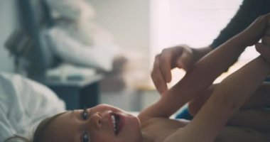 Anne, küçük oğluna krem sürüyor.