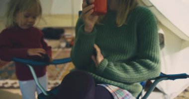 Anne ve oğlu dışarıda çadırın yanında dinleniyorlar.