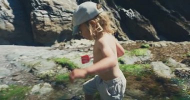 Deniz kıyısında yürüyen küçük çocuk