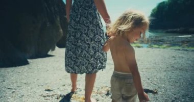 Anne ve oğul deniz sahilinde yürüyorlar.