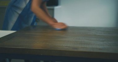 Evdeki masayı temizleyen kadın.