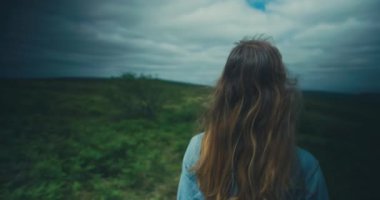 Yeşil alanda yürüyen genç bir kadın