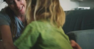 Evde küçük çocukla oynayan bir kadın.