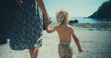 Anne ve oğul deniz sahilinde yürüyorlar.