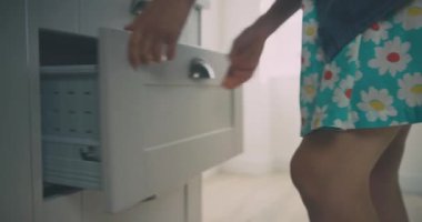 Evdeki dolaptan kaşığı alan kadın, oğlunun yanında.