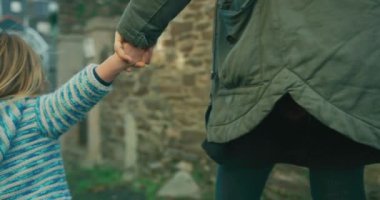 Anne ve küçük oğlu şehirde yürüyor.