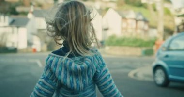 Anne ve küçük oğlu şehirde yürüyor.