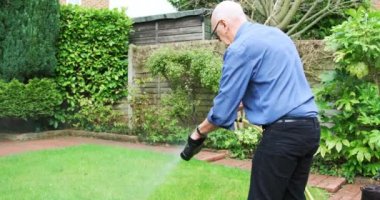 Dışarıda ayakkabı yıkayan kıdemli bir adam.