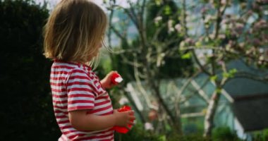 Sabun köpüklü küçük çocuk dışarıda oynuyor.