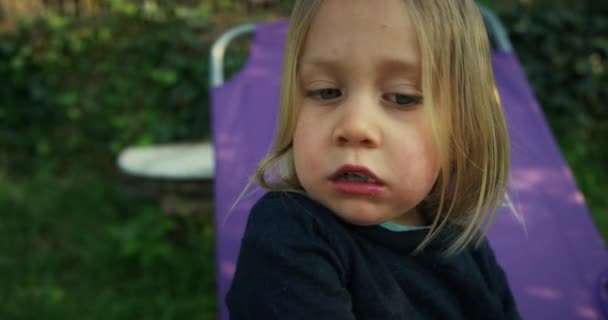キャンプ小屋の外に座っている間に食べる男の子 — ストック動画
