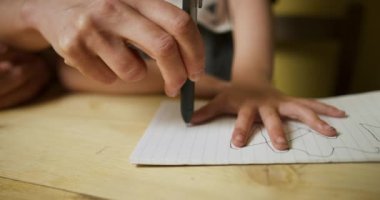 Anne, fotokopi kitabında oğlunu çiziyor.