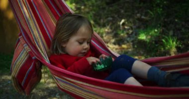 Ormandaki bir hamakta yatan tatlı çocuk.