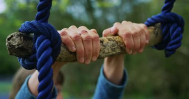 Küçük çocuk dışarıda salıncakla oynuyor.