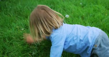 Küçük çocuk bahçede oynuyor.