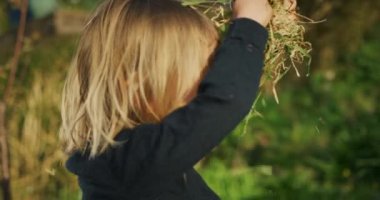 Küçük çocuk bahçede oynuyor.