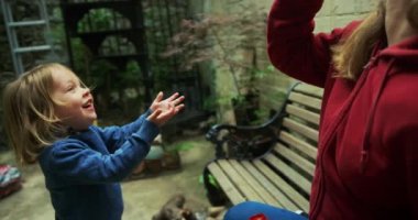 Küçük çocuğa sabun köpüğü üfleyen kadın. 