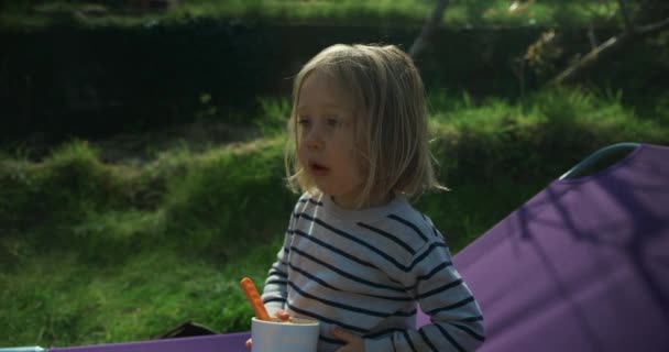 Niño Comiendo Mientras Está Sentado Cuna Del Campamento Afuera — Vídeo de stock