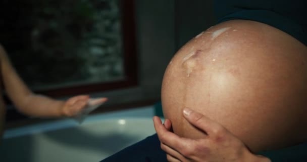 妊娠中の母親の腹に触れる男の子 — ストック動画