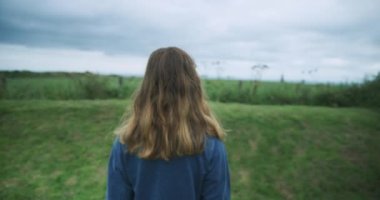 Yeşil alanda yürüyen genç bir kadın