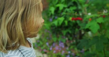 Küçük çocuk bahçede oynuyor.