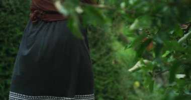 Genç bir anne ve oğlu bahçelerinden elma topluyor.