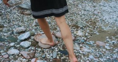 Deniz kumsalda yürüyen genç bir kadın