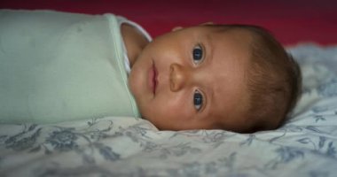 Sevimli küçük çocuk yatakta yatıyor.