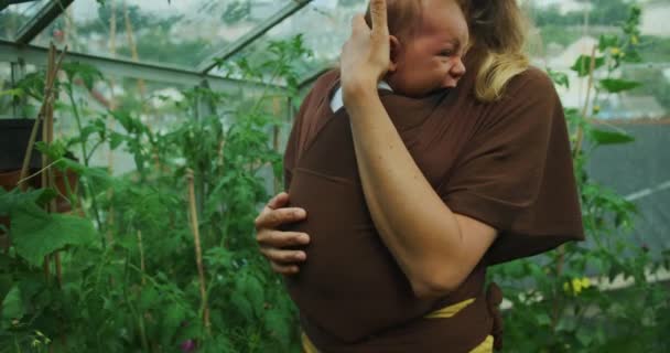 Young Woman Holding Her Son Greenhouse — Vídeos de Stock