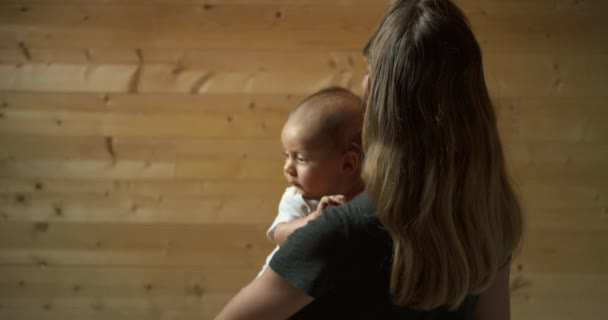 部屋に赤ちゃんと一緒にいる若い母親は — ストック動画