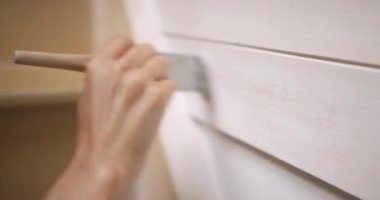 Evde mobilya boyayan bir kadın.