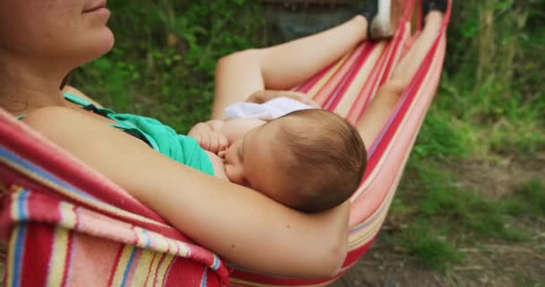 Mãe Alimentando Seu Bebê Enquanto Relaxa Rede — Vídeo de Stock