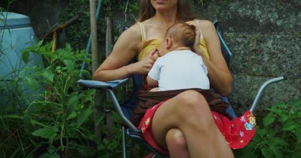 Mother Feeding Her Baby Boy While Sitting Garden Chair — Stockvideo