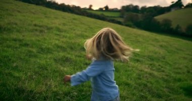 Komik küçük çocuk kendini mutlu hissediyor ve sahada oynuyor.