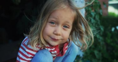 Küçük çocuk pencerenin kenarında oturuyor.