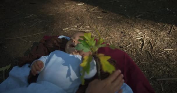可爱的小男孩躺在森林的地面上 玩秋叶 — 图库视频影像