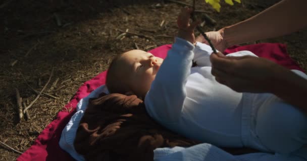 可爱的小男孩躺在森林的地面上 玩秋叶 — 图库视频影像