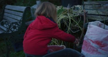 Küçük çocuk dışarıda çekiçle buz kırıyor.