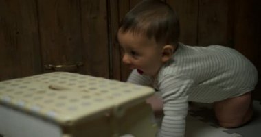 Sevimli küçük erkek bebek ayakta durmaya çalışıyor sandalyeye yaslanarak.